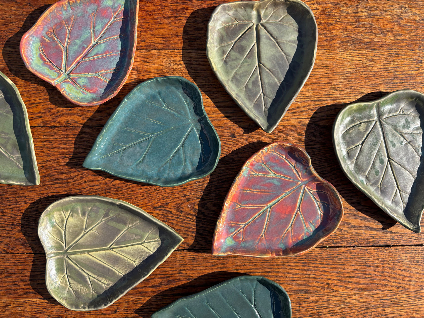 Ceramic leaf-shaped dishes on a wooden surface